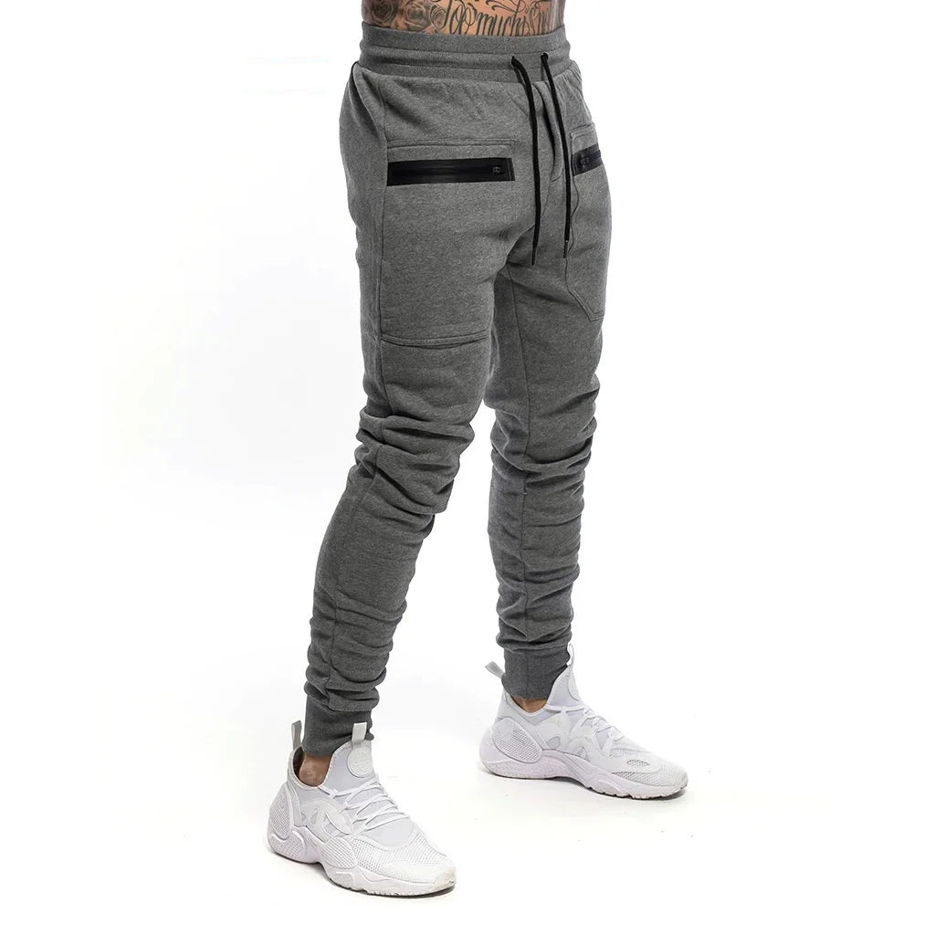 Calça de moletom fitness masculina, confeccionada em algodão premium, com bolsos com zíper e cintura ajustável. Perfeita para treinos e conforto diário.