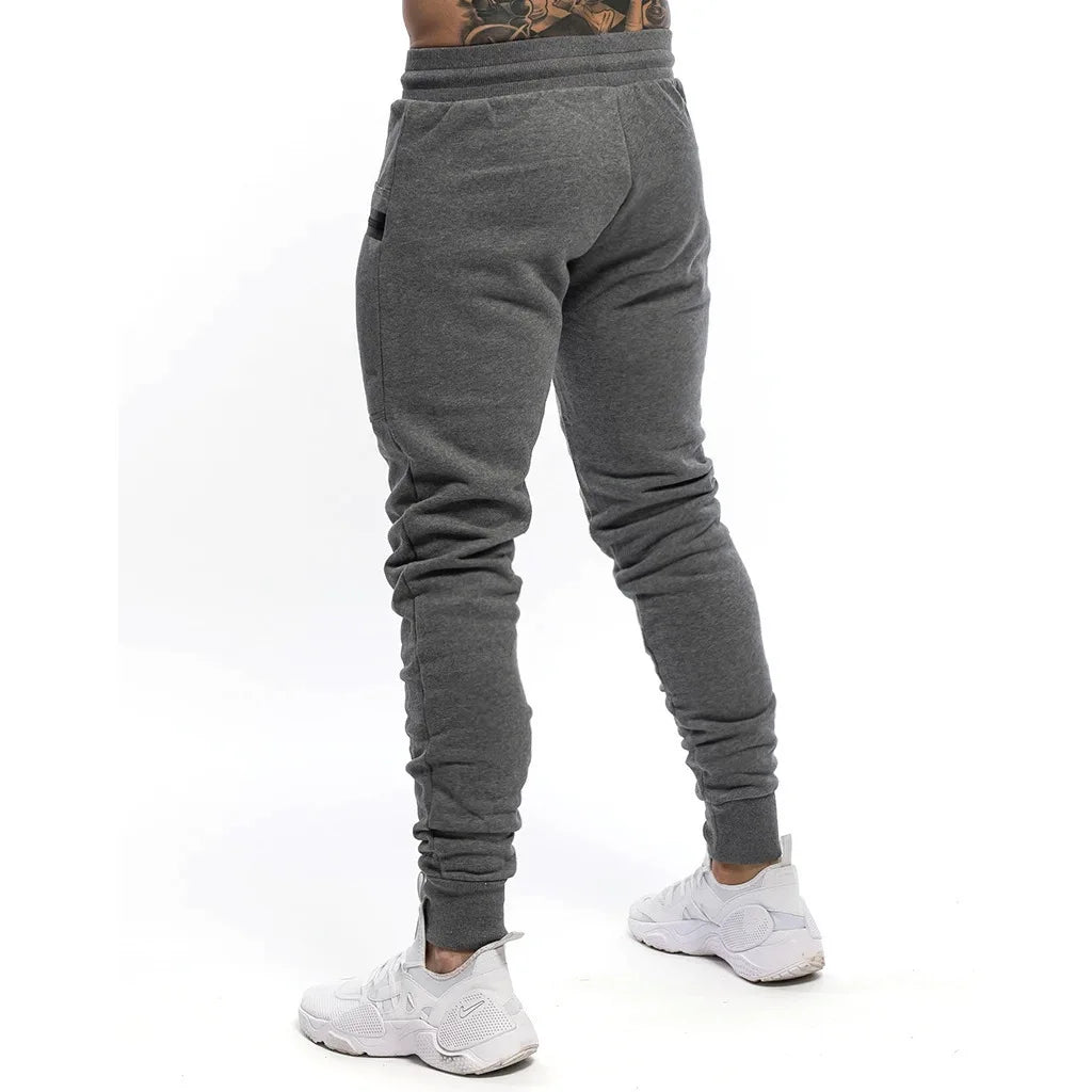 Calça de moletom fitness masculina, confeccionada em algodão premium, com bolsos com zíper e cintura ajustável. Perfeita para treinos e conforto diário.