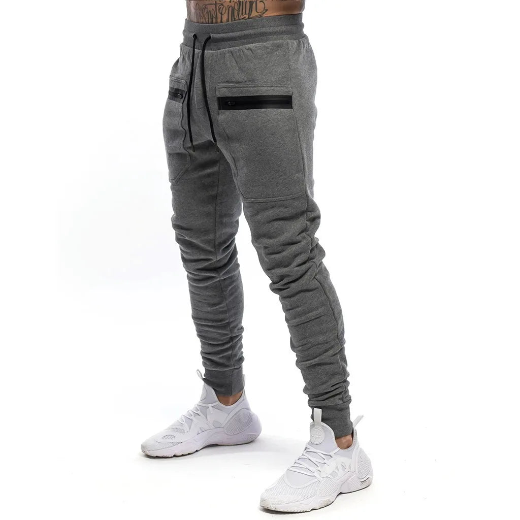Calça de moletom fitness masculina, confeccionada em algodão premium, com bolsos com zíper e cintura ajustável. Perfeita para treinos e conforto diário.