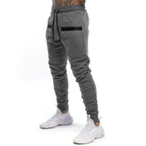 Calça de moletom fitness masculina, confeccionada em algodão premium, com bolsos com zíper e cintura ajustável. Perfeita para treinos e conforto diário.
