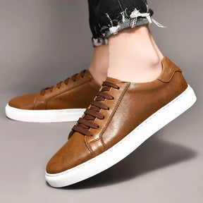 Tênis Masculino em Couro Romenzi RZ409 com design clean e solado de borracha, disponível em marrom e preto, perfeito para uso casual ou elegante.
